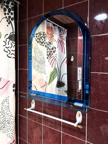 a mirror on a tiled wall in a bathroom at Won stay in Osan