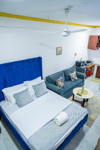 a bedroom with a large bed and a couch at Nayas Haven Studio2 in Mombasa Bamburi Mtambo Mwembeni with hot shower in Mombasa