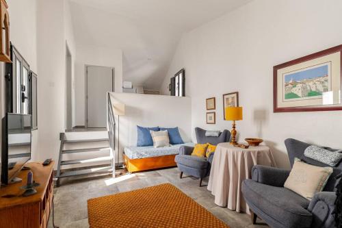 a living room with a couch and chairs and a table at Casas da Colmeia T1 Grey Stairs in Reguengos de Monsaraz