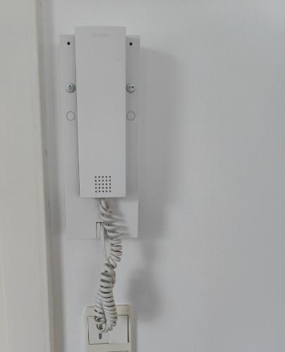 a white phone hanging from a wall at Waterfront - Apartment - free parking in Nørresundby