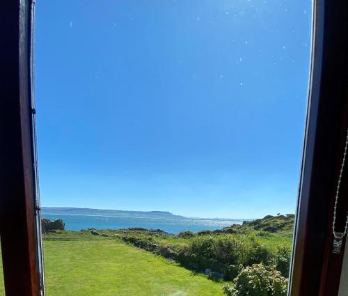 a view of the ocean from a train window at Sea View Upper Apartment in Greencastle