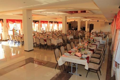 a large banquet hall with white tables and chairs at Gościniec Europejski in Miedziana Góra