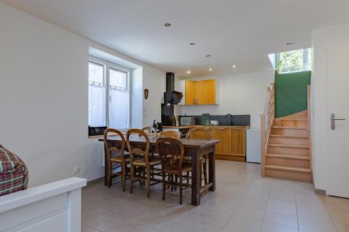 une cuisine et une salle à manger avec une table et des chaises dans l'établissement L'Arche aux Peyruches, à Assieu