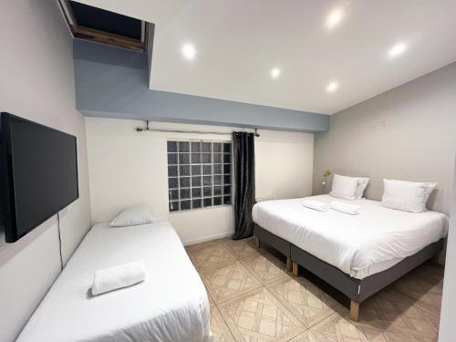 une chambre avec deux lits et une télévision à écran plat dans l'établissement Urban Flat 86 - Charming Paris Central Flat, à Paris