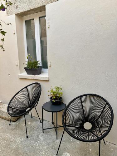 two chairs and a table in front of a building at Suite Au grand air in Châteauneuf-du-Faou
