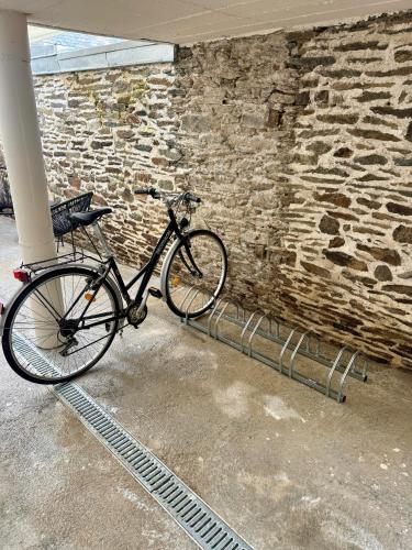 a bike parked next to a brick wall at Suite Au grand air in Châteauneuf-du-Faou