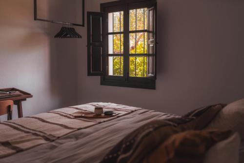 a bedroom with a bed and a window with a cup on it at Villa Bellido in Alora