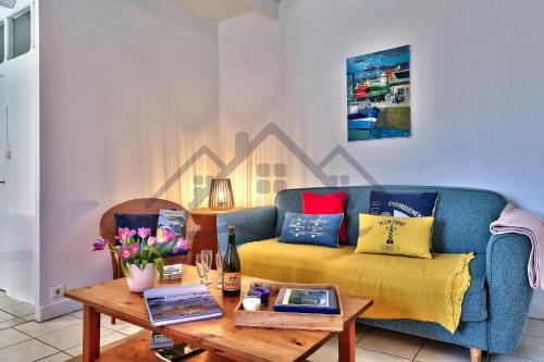 un salon avec un canapé et une table dans l'établissement LocaLise - M26B - Les Belles Âmes - Maison rénovée avec jardin entièrement clos - place de parking sur le terrain - wifi inclus - draps inclus - animaux bienvenus, au Guilvinec