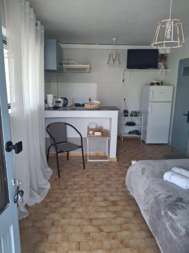a room with a kitchen and a table and a bed at Alexandra Studios in Néos Pírgos