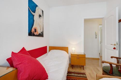 a bedroom with a bed with red and white pillows at Casa Marta in Cavalese