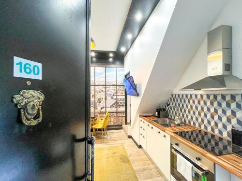une cuisine avec une porte noire munie d'un panneau. dans l'établissement Urban Flat 160 - Fashion week Paris Central flat, à Paris