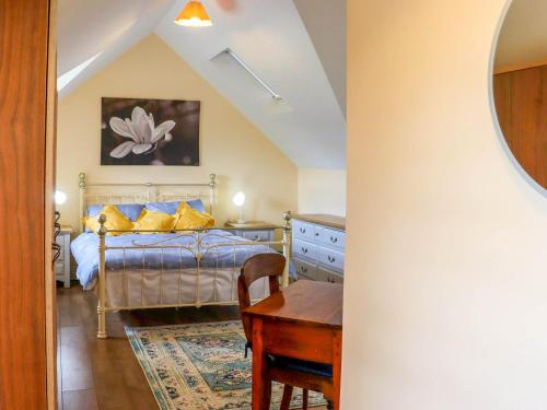 Kilcash Castle Cottage في Kilcash: غرفة نوم بها سرير ومكتب وطاولة
