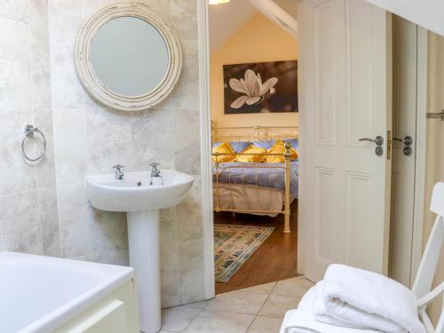 Kilcash Castle Cottage في Kilcash: حمام مع حوض وغرفة نوم