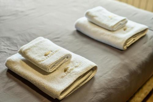 two towels sitting on top of a bed at Cabañas Villa Labrador con costa de lago in San Carlos de Bariloche