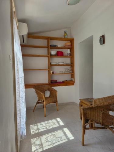 a room with a chair and a table and shelves at Nonza vue sur mer in Nonza