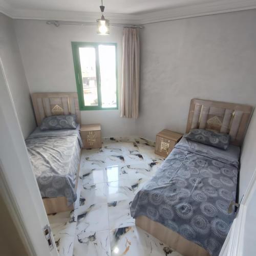 a room with two beds and a window at tanger in Aïn Diab