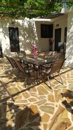 a glass table and chairs on a stone patio at Michaela's House in Tsikalariá