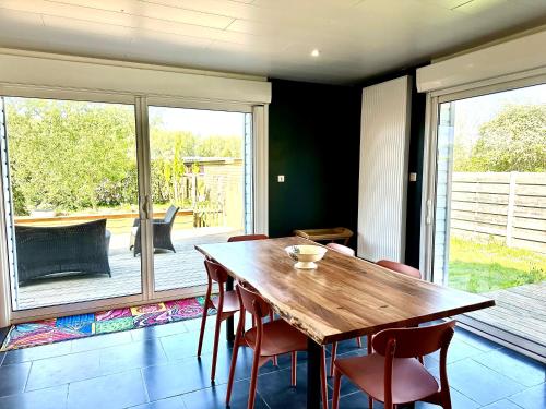 a dining room with a wooden table and chairs at La Framboisine - Calme -Moderne - Jardin - Wifi in Favières