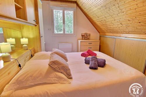 une chambre avec un grand lit avec deux oreillers dessus dans l'établissement Cocon Breton, à Marzan