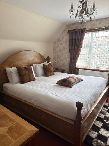 a bedroom with a large bed with a wooden headboard at Wimberley House in Inverness