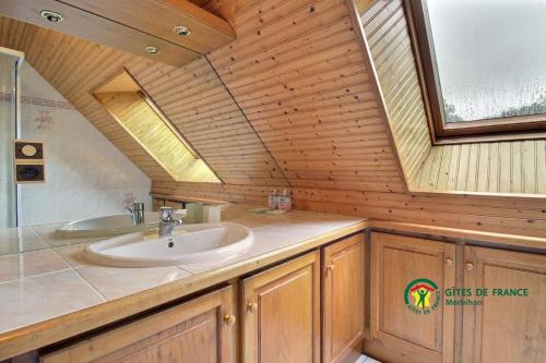 une salle de bain avec un lavabo et un miroir dans l'établissement Cocon Breton, à Marzan