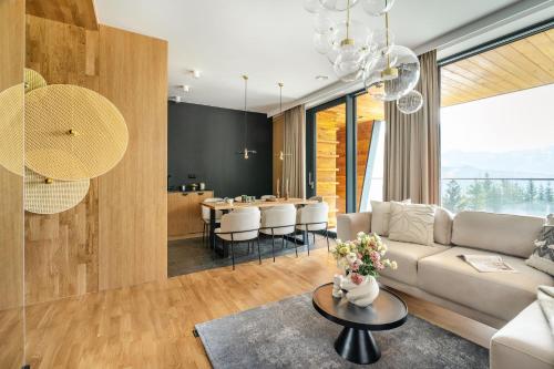 a living room with a couch and a table at Landscape Villas - LoftAffair Spa Collection in Kościelisko