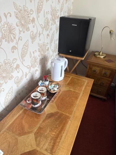 a table with a tray of cupcakes and a tv at Wimberley House in Inverness