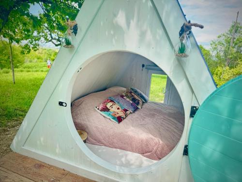 a bed in a play tent in a field at Bohemian ECO lodge in Kisapáti