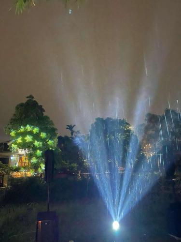 a water fountain in a park at night at Vườn Tùng RiverSide retreat & Villa - KDT ECOPARK in Kim Quan