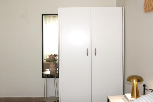 a white wardrobe in a bedroom with a mirror at Fissas Rooms in Sivota
