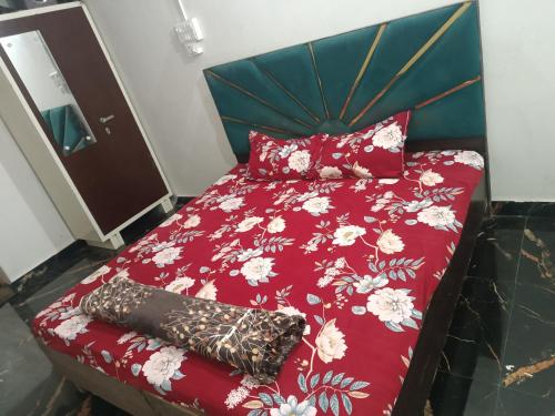 a bed with a red comforter and pillows at Mathura vrindavan Gokul Dham in Mathura
