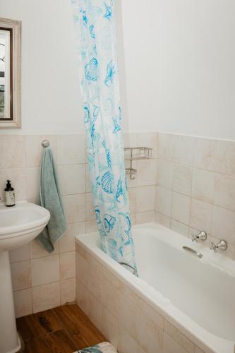 a bathroom with a bath tub and a sink at Mooi Uitsig Lodge in Paarl