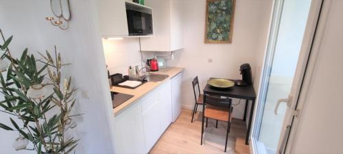 - une petite cuisine avec une table et un comptoir dans l'établissement Grand Studio avec Terrasse et Parking - Vieux- Lille - Blaise, à Lille