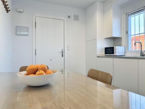 a bowl of oranges sitting on a table in a kitchen at Apartamentos Turísticos Santo Rostro in Chipiona
