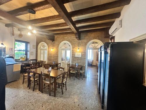 a dining room with a table and a refrigerator at Locanda alla stazione in Latisana