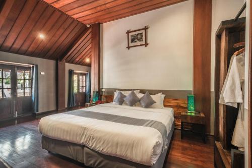 a bedroom with a large bed in a room at Sanctuary Hotel Luang Prabang in Luang Prabang