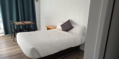 a bedroom with a white bed with a pillow on it at Hébergements ASLC Baie-Comeau in Baie-Comeau