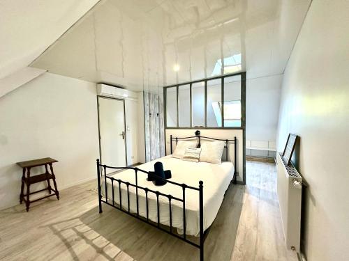 a bedroom with a bed and a table in it at La Framboisine - Calme -Moderne - Jardin - Wifi in Favières