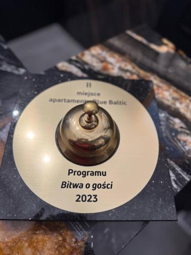 a plate with a medal on top of a table at Apartamenty BLUE BALTIC SPA Jacuzzi & Sauna MORZE in Chłopy