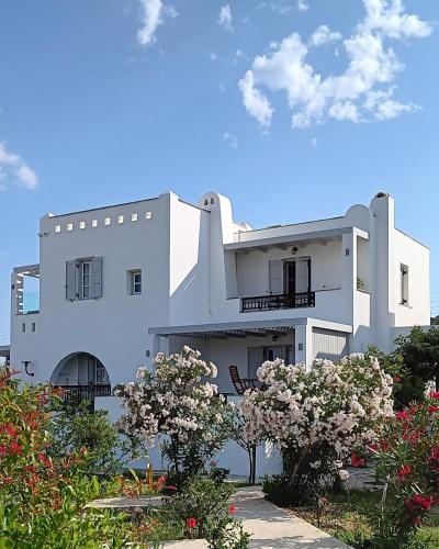 a white building with flowers in front of it at Sea Lilies Suites in Plaka
