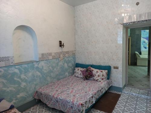 a bedroom with a bed in the corner of a room at Номер у моря, бассейн, сад, мангал in Odesa
