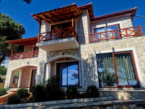 a house with a balcony on top of it at Villa Kristiano 21 in Sarandë
