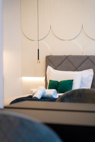 a bedroom with a bed with green and white pillows at Tsarevets Boutique Hotel & SPA in Veliko Tŭrnovo