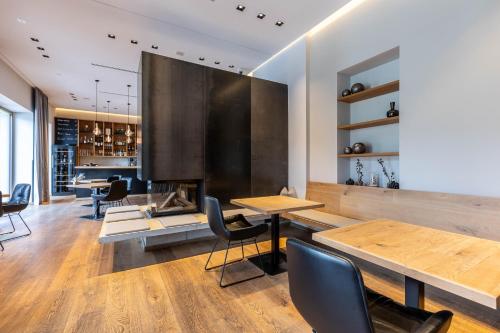 a dining room with tables and chairs and a fireplace at Seehotel Bellevue by keyone in Zell am See