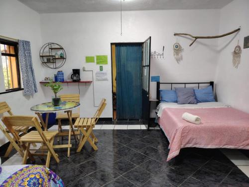 a bedroom with a bed and a table and chairs at Ganesha HOSTAL in Mexico City