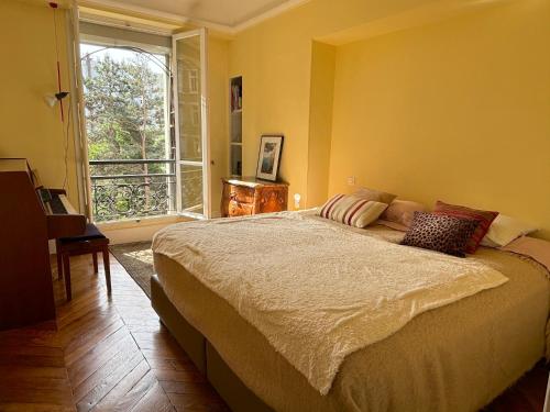 une chambre avec un grand lit et une fenêtre dans l'établissement L'appartement Michelangelo, à Paris