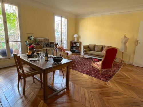un salon avec une table et un canapé dans l'établissement L'appartement Michelangelo, à Paris