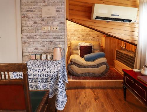 a living room with a table and a couch and a staircase at Leon Rooms in Tbilisi City