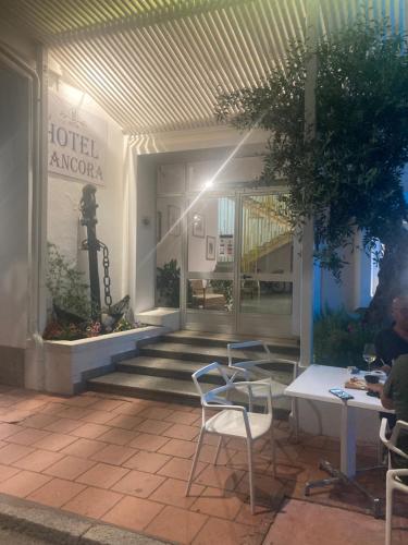 a lobby of a hotel with chairs and a table at Hotel L'Ancora in La Caletta
