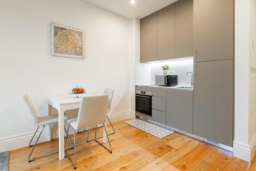 a kitchen with a table and chairs and a refrigerator at Plaza Apartments by HostWise in Guimarães